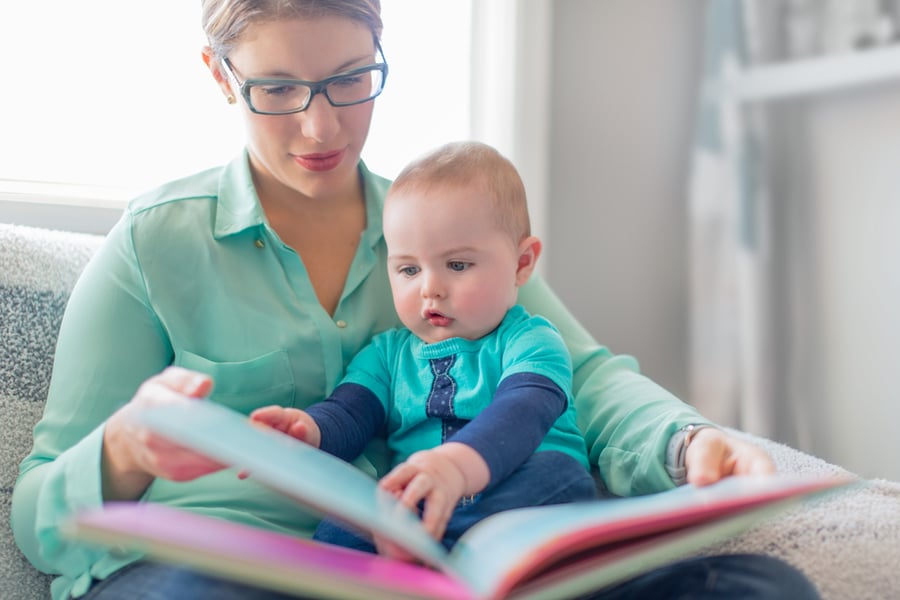 Cute baby reading with his mother